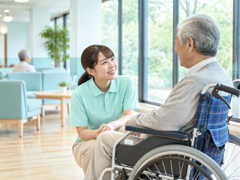介護スタッフが車いすの方と笑顔で会話する様子